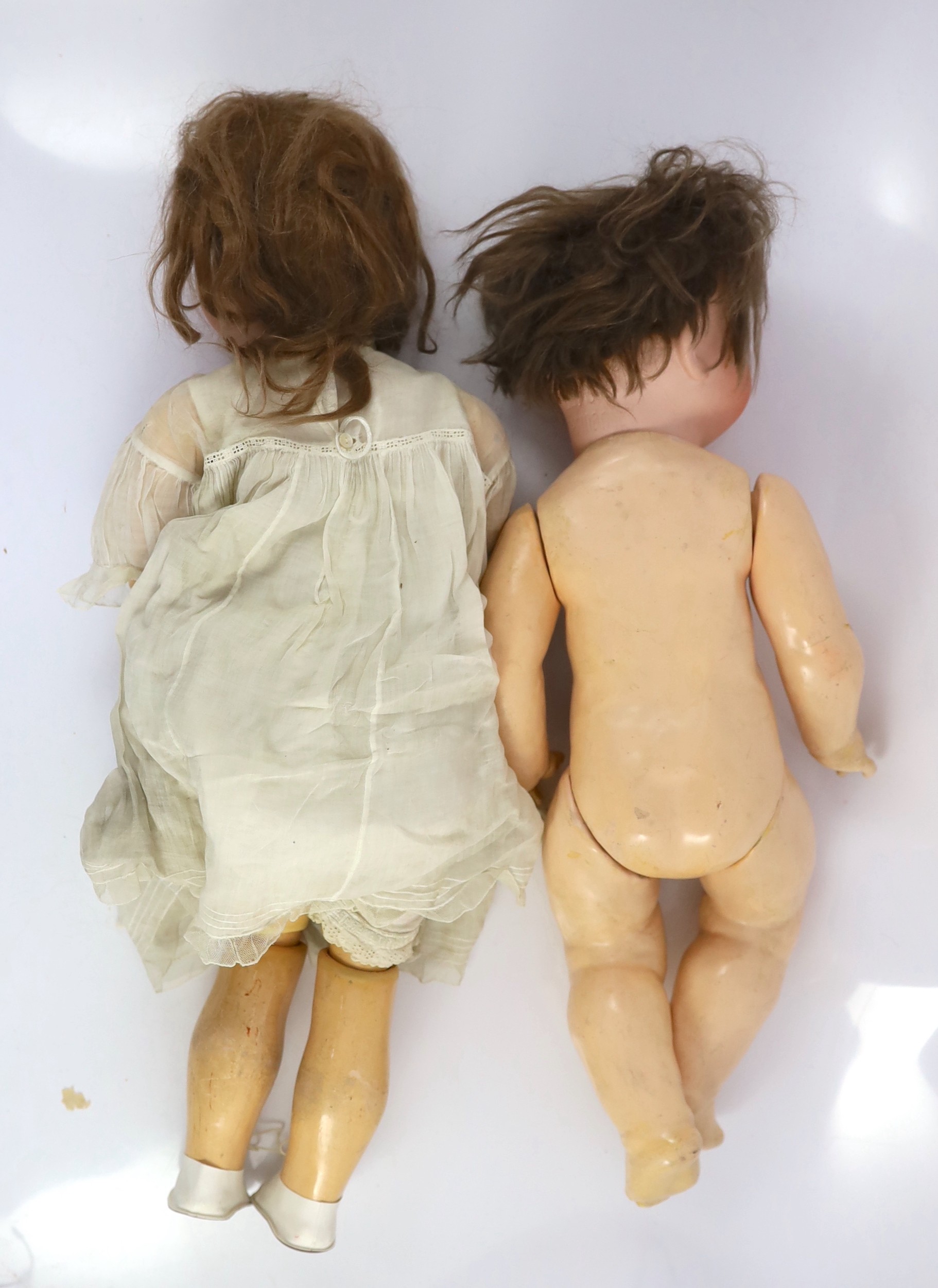 An Armand Marseille bisque doll, German, circa 1912, 24in. and 21in. resp.